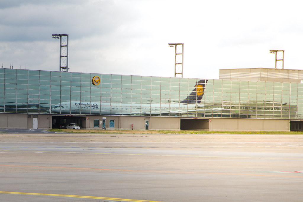 Frankfurt Airport: Lufthansa Flugzeug spiegelt sich in der Gebäude-Glasfront |